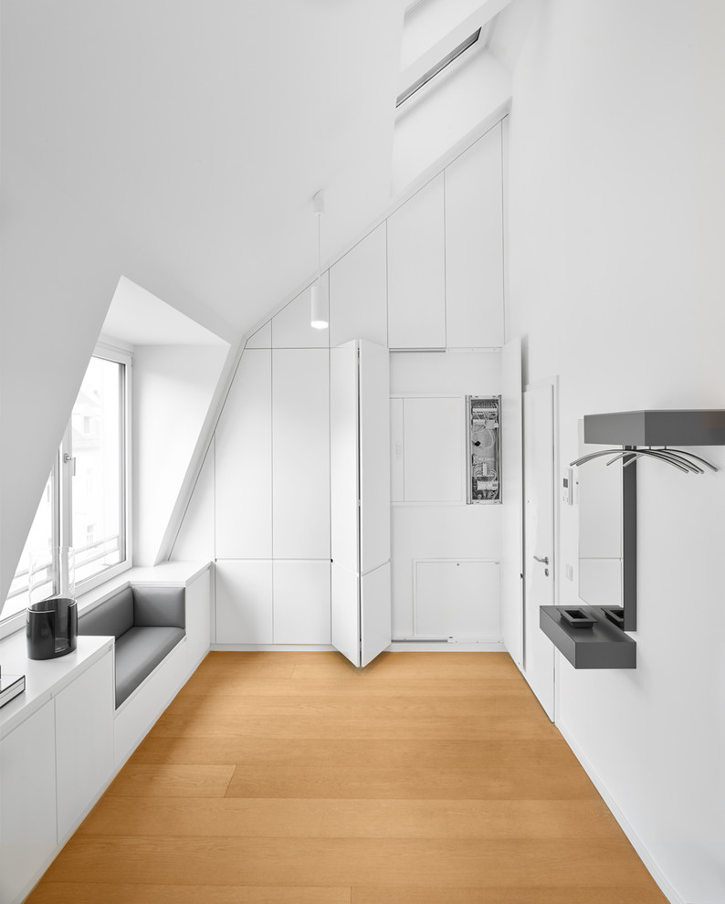 Offenes Modernes Esszimmer mit weißer Wandfarbe, hellem Holzboden und beigem Boden in München