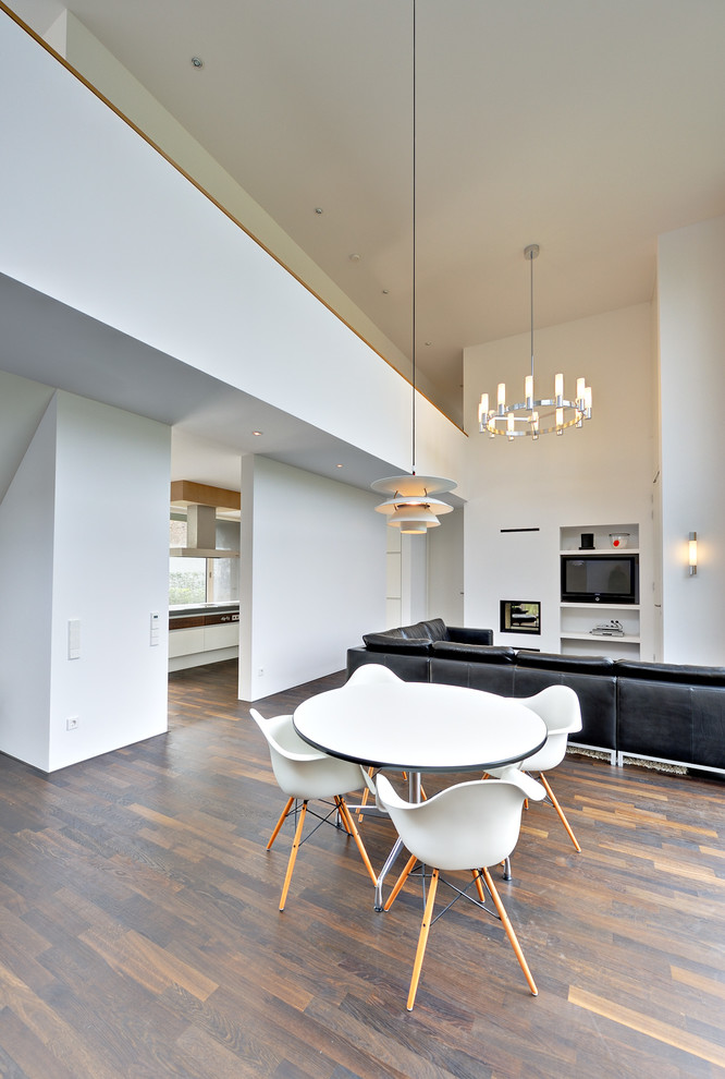 Photo of a large contemporary open plan dining room in Berlin with white walls and dark hardwood flooring.