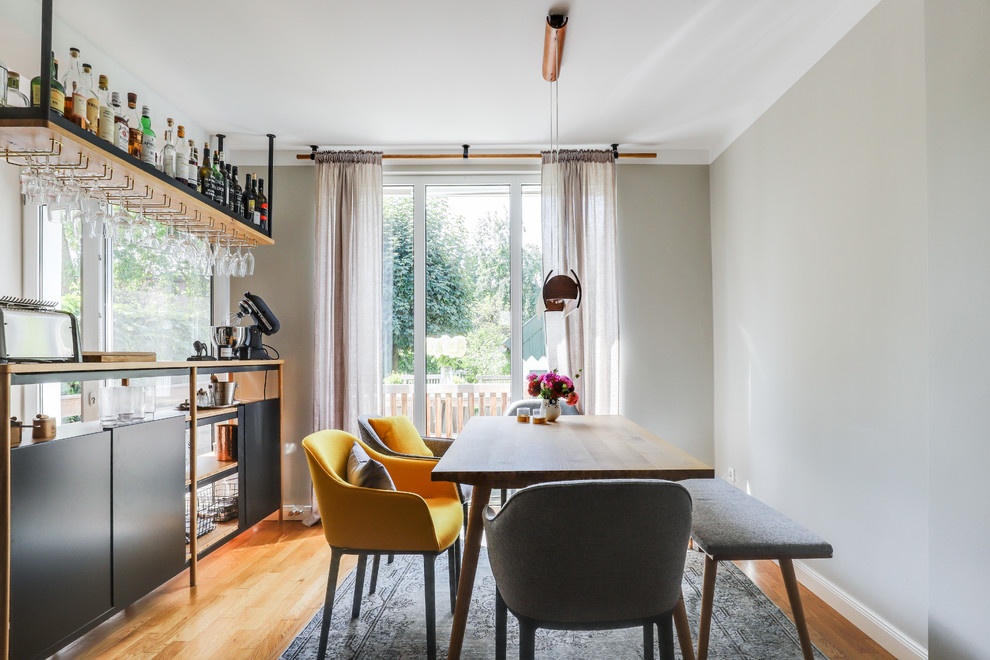 Esempio di una sala da pranzo aperta verso il soggiorno contemporanea di medie dimensioni con pareti beige, parquet chiaro, stufa a legna e pavimento marrone