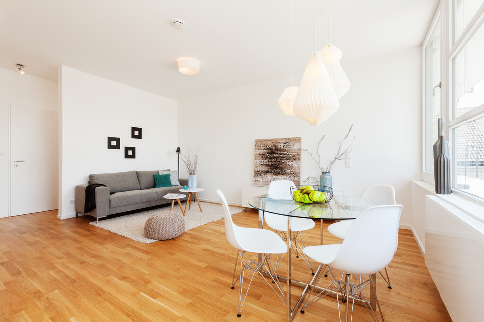 Idée de décoration pour une petite salle à manger minimaliste fermée avec un mur blanc et un sol en bois brun.