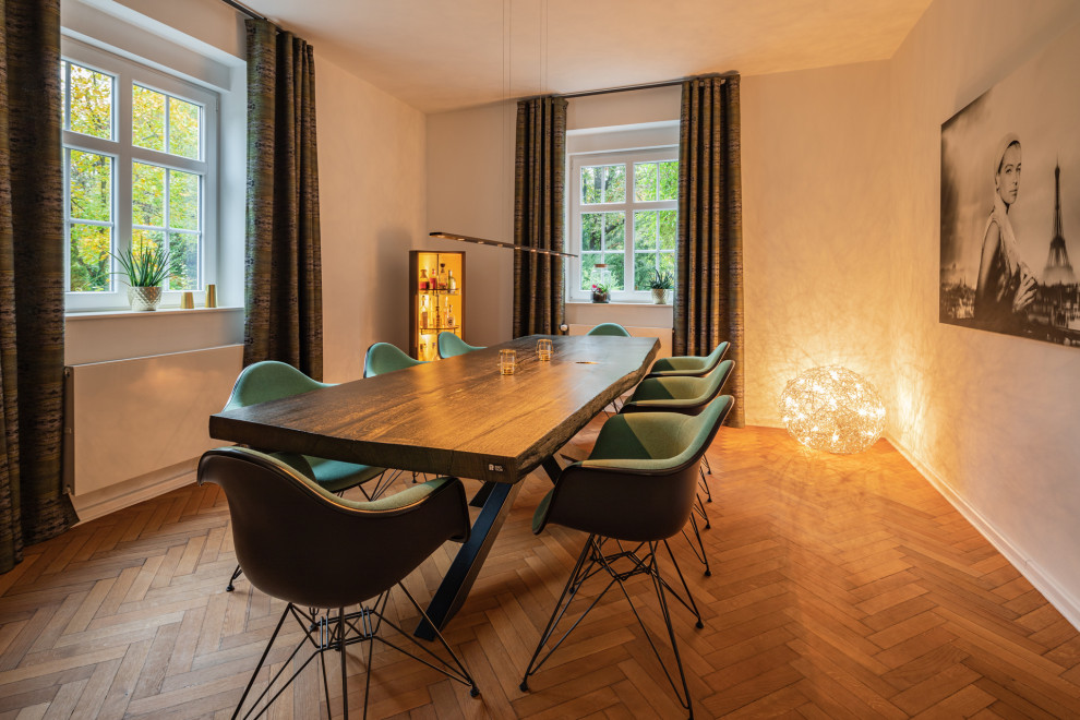 Offenes Modernes Esszimmer mit weißer Wandfarbe und gebeiztem Holzboden in Dortmund