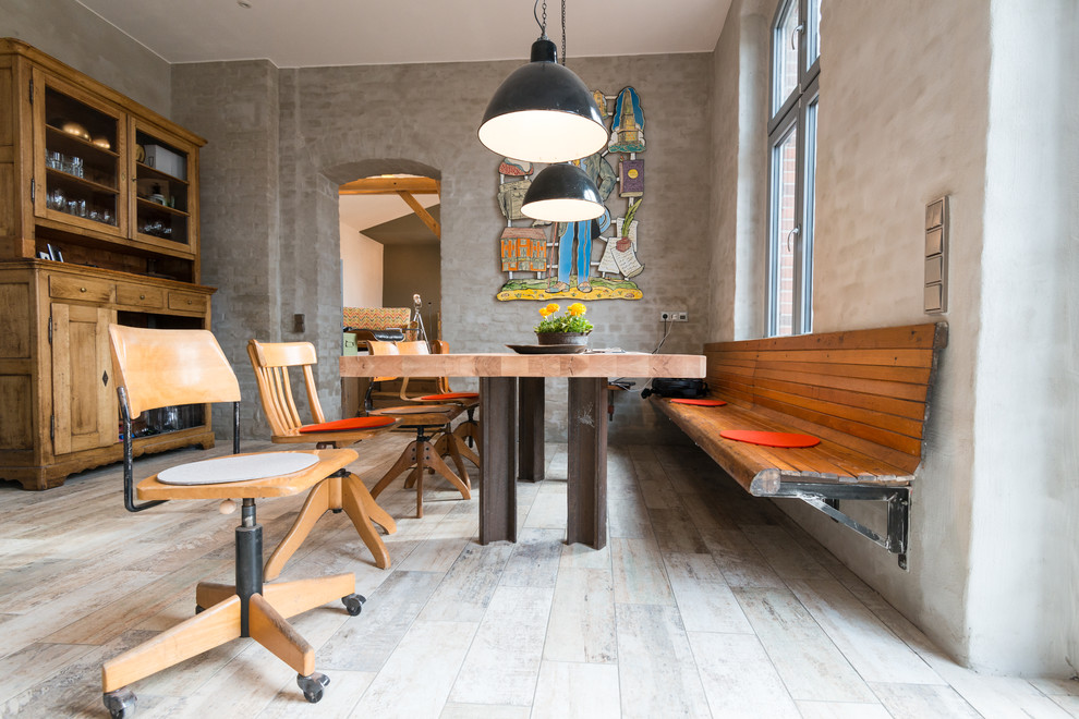 Foto di una sala da pranzo aperta verso il soggiorno bohémian di medie dimensioni con pareti grigie, nessun camino e pavimento in legno verniciato