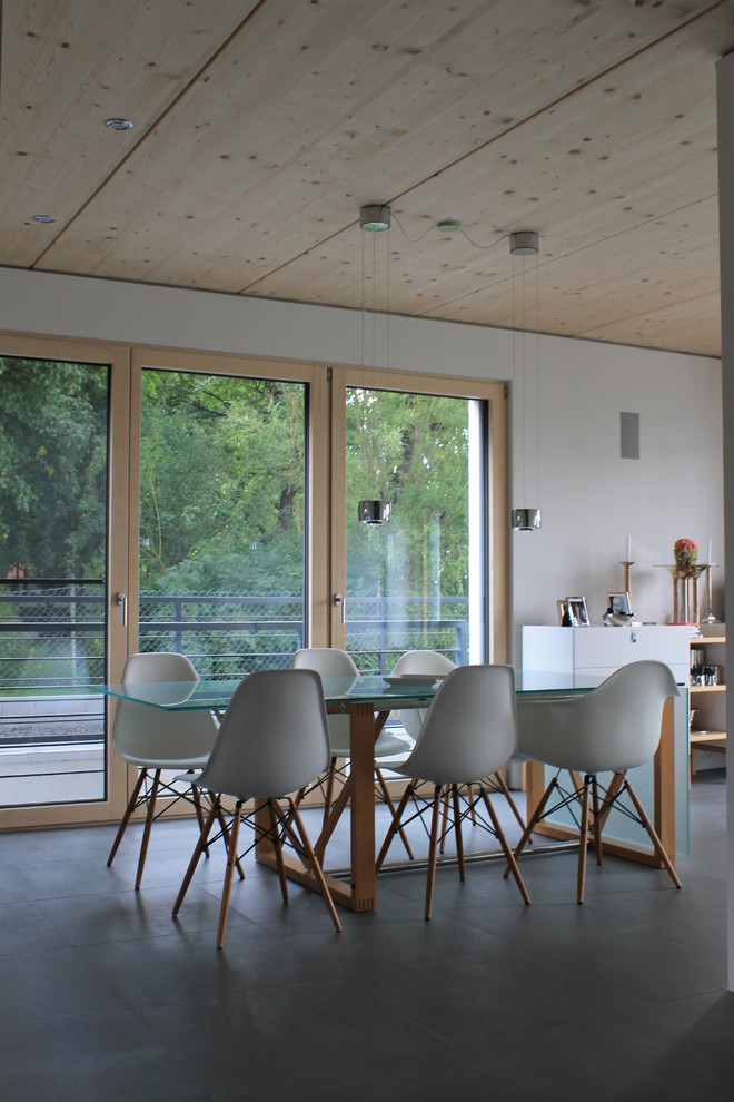 Стильный дизайн: отдельная столовая среднего размера в современном стиле с белыми стенами и серым полом без камина - последний тренд