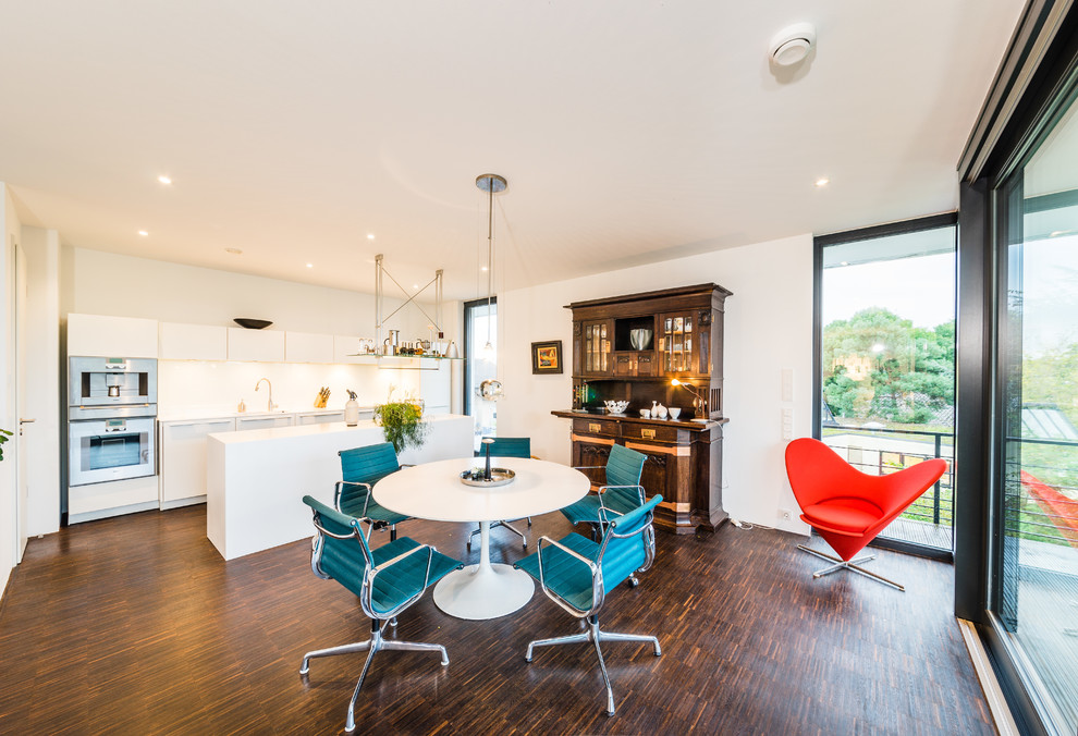 Photo of a large contemporary kitchen/dining room in Frankfurt with white walls and dark hardwood flooring.
