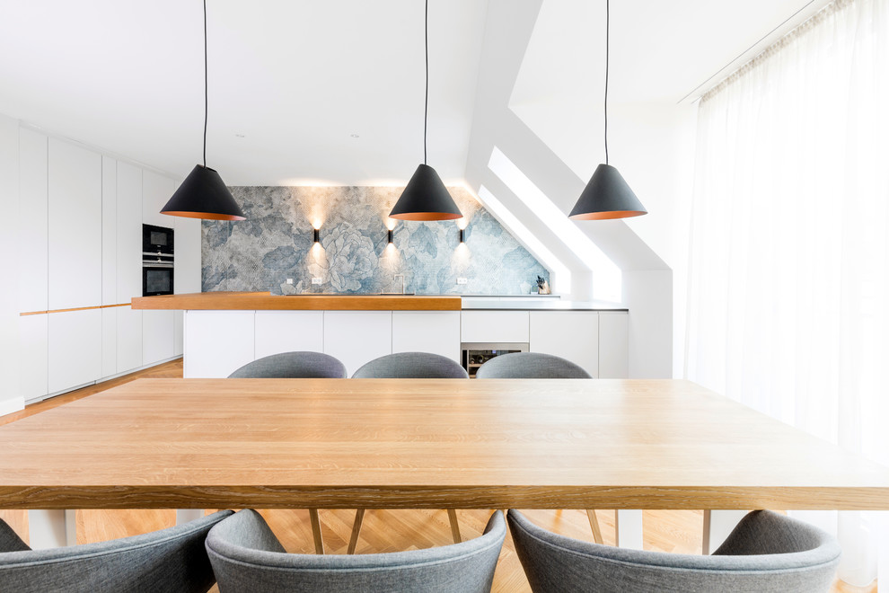Diseño de comedor de cocina nórdico grande sin chimenea con paredes blancas, suelo de madera en tonos medios y suelo marrón