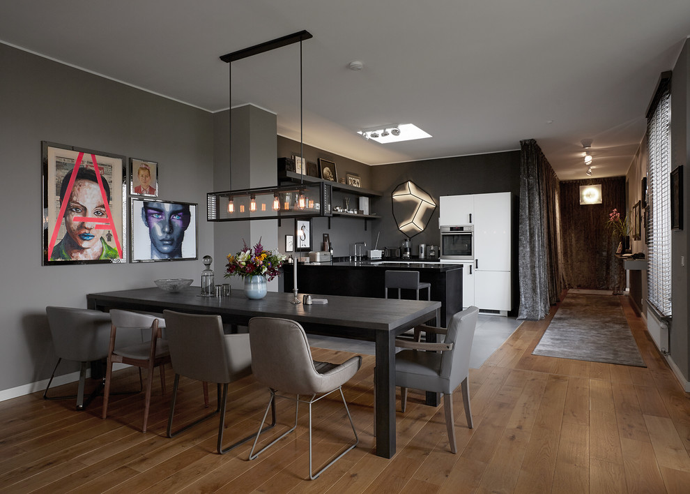 Aménagement d'une salle à manger ouverte sur la cuisine contemporaine de taille moyenne avec un mur marron, un sol en bois brun, aucune cheminée et un sol marron.