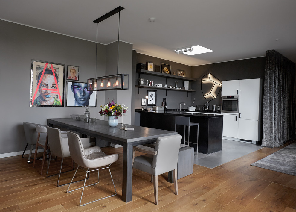 Mittelgroße Moderne Wohnküche ohne Kamin mit grauer Wandfarbe, braunem Holzboden und braunem Boden in Berlin