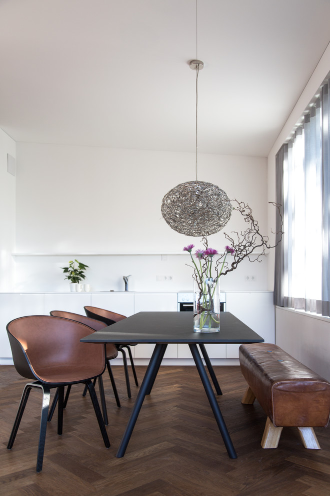 Idée de décoration pour une salle à manger ouverte sur la cuisine nordique de taille moyenne avec un mur blanc et parquet foncé.