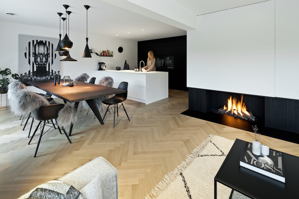 ミュンヘンにある広いコンテンポラリースタイルのおしゃれなダイニングキッチン (白い壁、淡色無垢フローリング、横長型暖炉、漆喰の暖炉まわり、ベージュの床) の写真