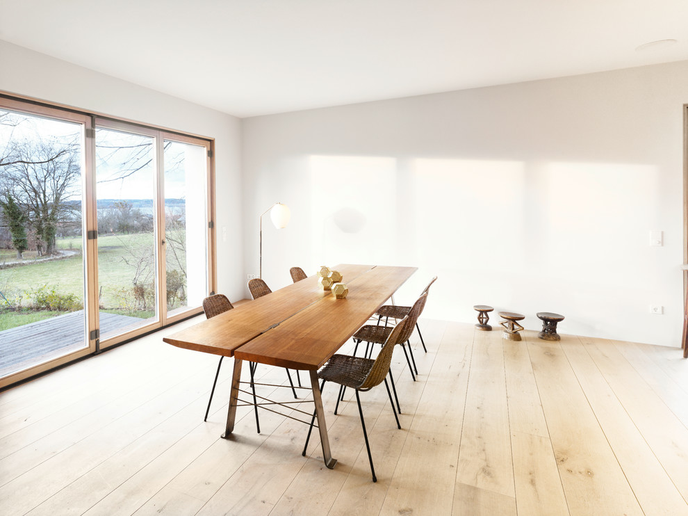 Ejemplo de comedor nórdico grande con paredes blancas y suelo de madera clara