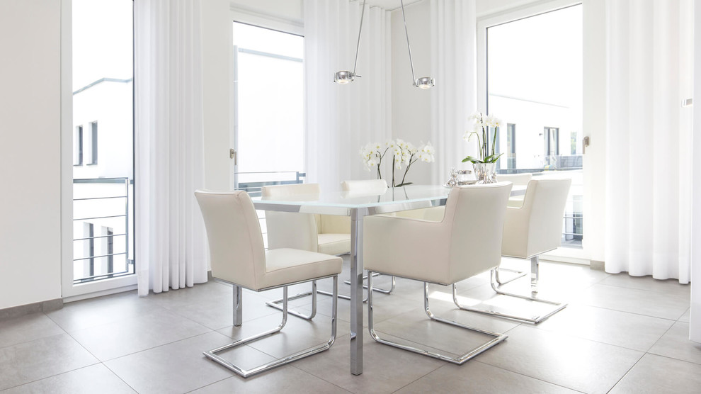 Photo of a medium sized contemporary enclosed dining room in Dortmund with white walls, ceramic flooring, no fireplace and grey floors.