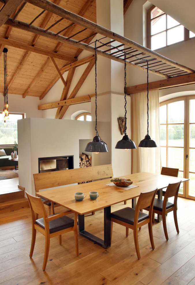 Пример оригинального дизайна: гостиная-столовая в стиле кантри с белыми стенами, паркетным полом среднего тона, коричневым полом, балками на потолке, сводчатым потолком и деревянным потолком