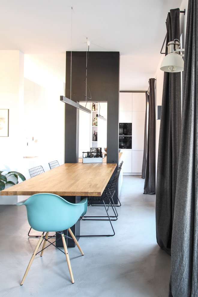 Cette photo montre une salle à manger ouverte sur la cuisine scandinave de taille moyenne avec un mur noir et sol en béton ciré.