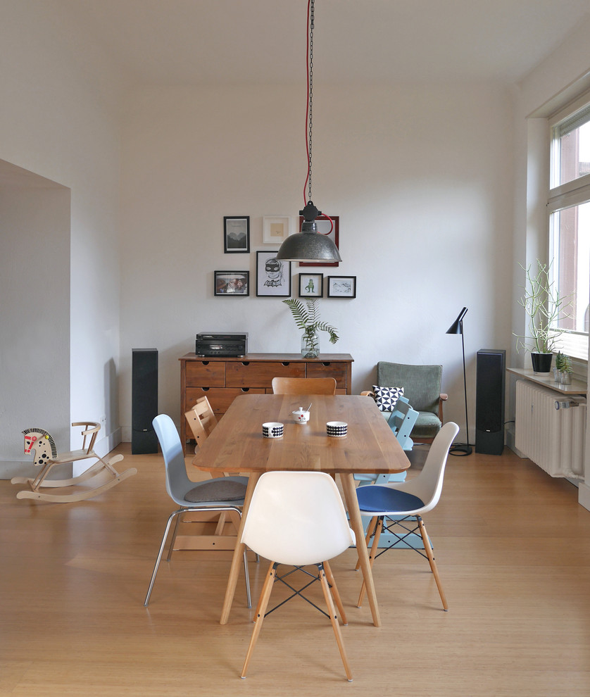 Aménagement d'une salle à manger ouverte sur le salon contemporaine de taille moyenne avec un mur blanc, un sol en bois brun, aucune cheminée et un sol marron.