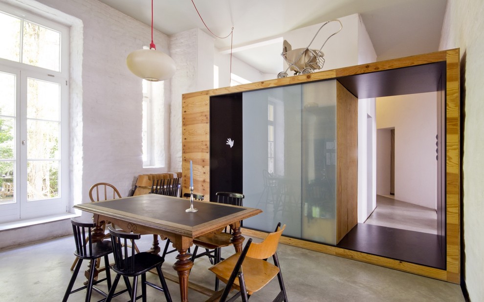 Immagine di una sala da pranzo minimal con pavimento in cemento