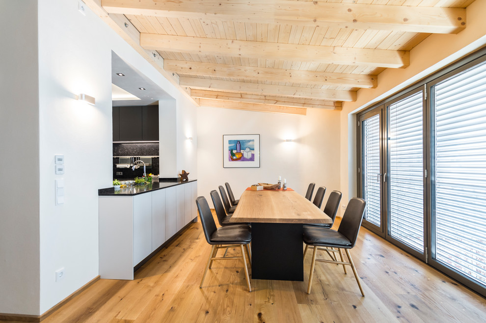 Mittelgroße Moderne Wohnküche mit weißer Wandfarbe, hellem Holzboden und braunem Boden in Leipzig