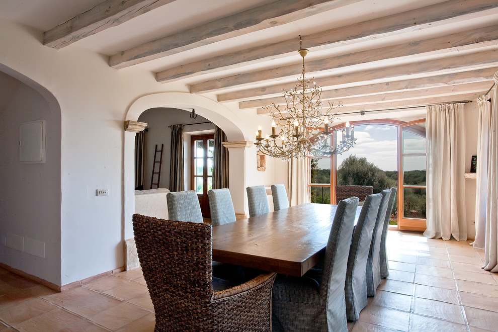 На фото: большая гостиная-столовая в средиземноморском стиле с бежевыми стенами и полом из терракотовой плитки