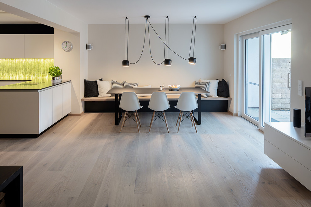 Mittelgroße Moderne Wohnküche ohne Kamin mit weißer Wandfarbe, hellem Holzboden und blauem Boden in München