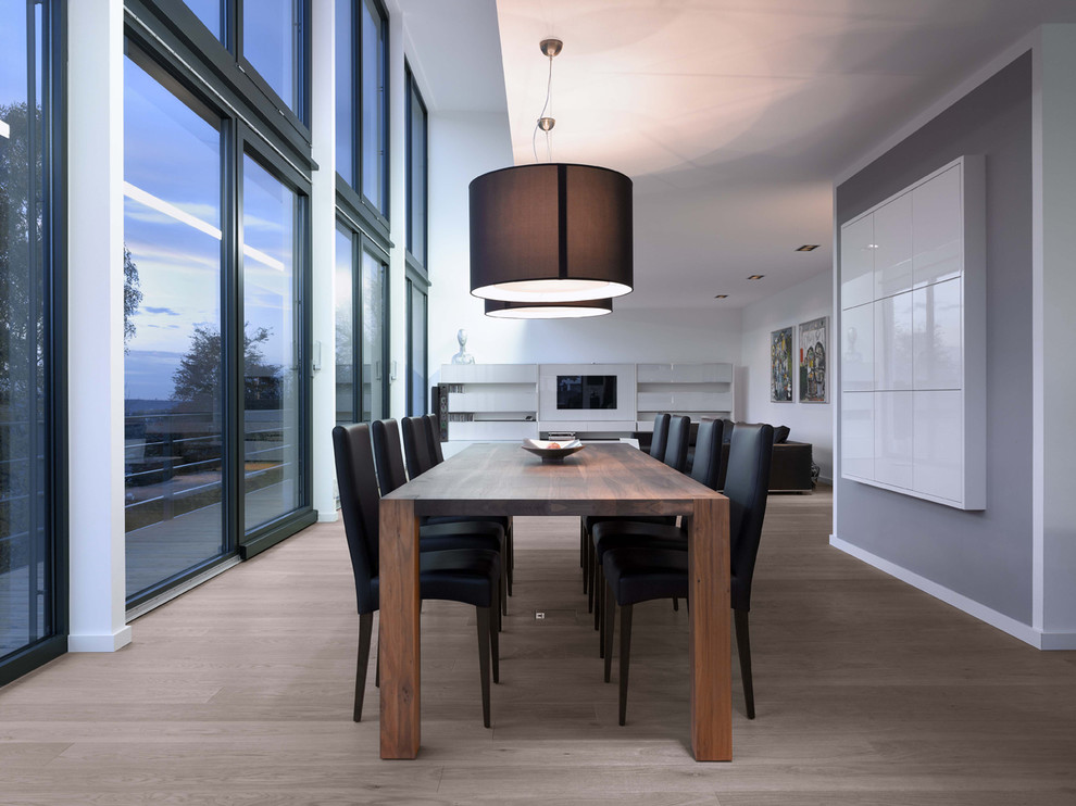 Photo of a large contemporary open plan dining room in Stuttgart with grey walls and medium hardwood flooring.