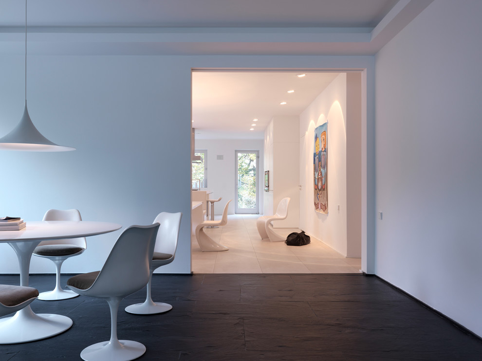 Ispirazione per una sala da pranzo moderna con pareti bianche e pavimento in ardesia