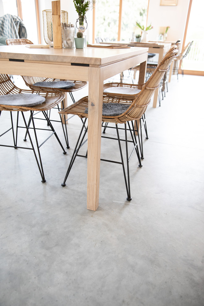 Inspiration for an urban dining room in Munich with concrete flooring.