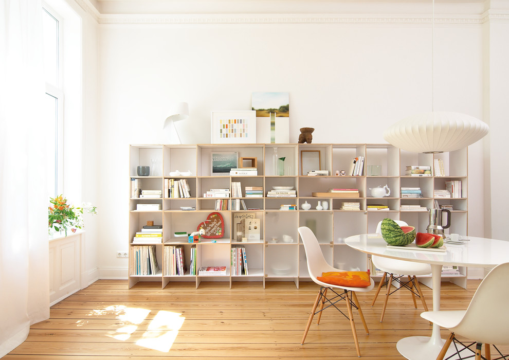Inspiration pour une salle à manger design avec un mur blanc et parquet clair.