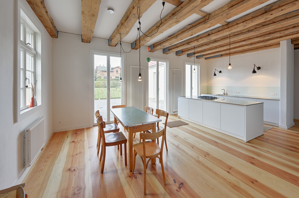 Imagen de comedor de cocina contemporáneo con paredes blancas y suelo de madera en tonos medios