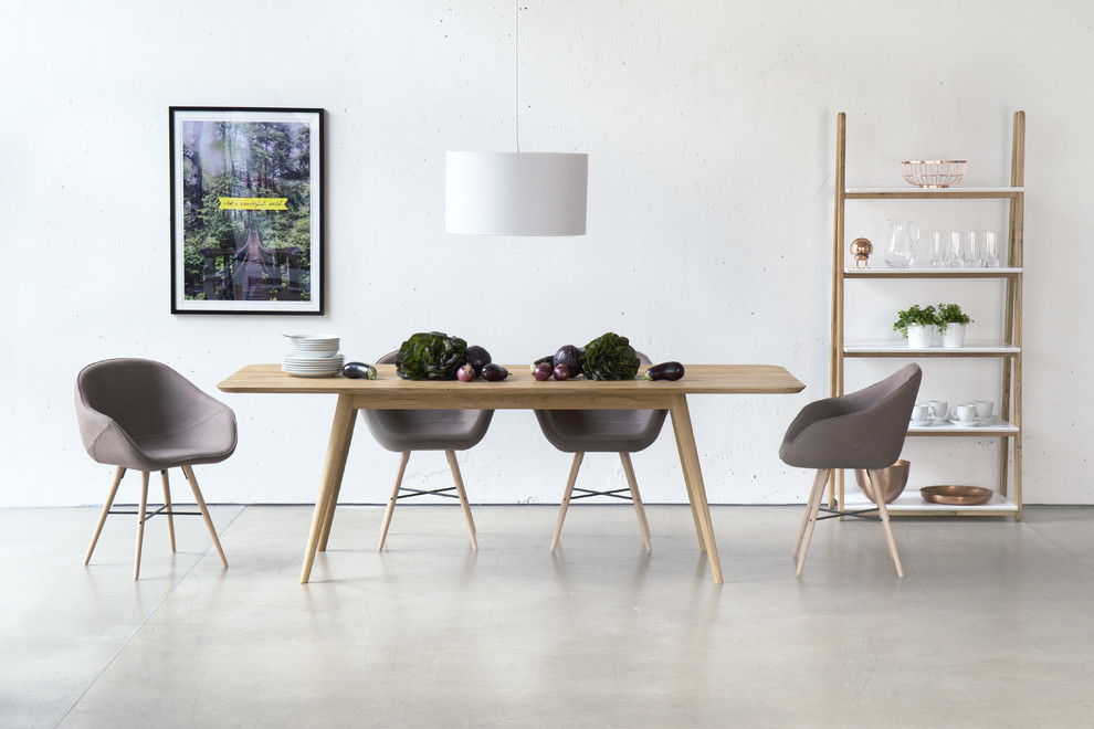 This is an example of a scandi dining room in Berlin with white walls and concrete flooring.