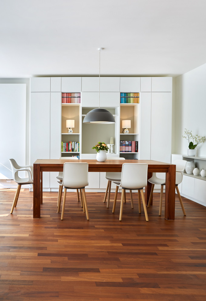 Inspiration pour une salle à manger ouverte sur le salon design de taille moyenne avec un mur blanc, un sol en bois brun et un sol orange.