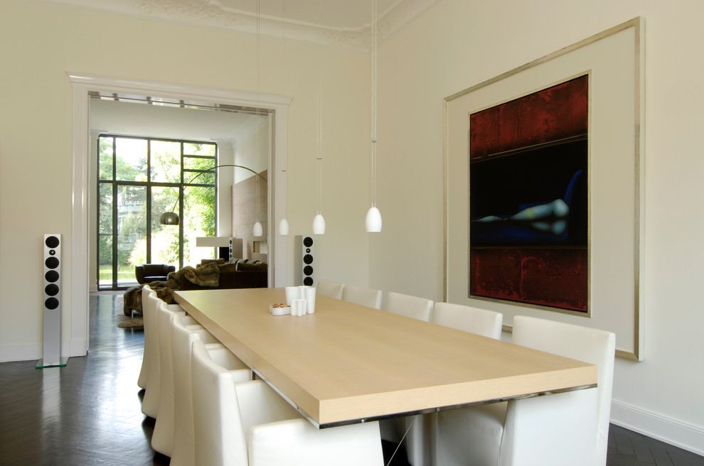 Imagen de comedor contemporáneo grande abierto con paredes beige y suelo de madera oscura