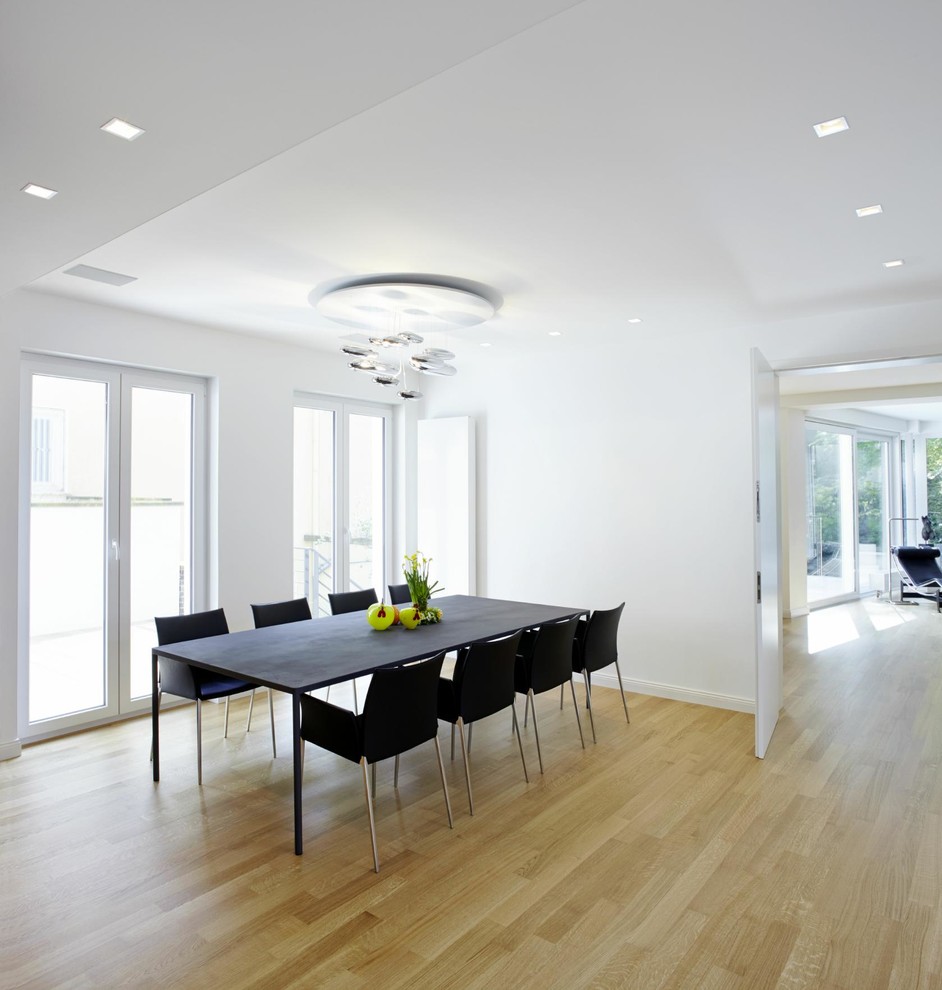 Contemporary enclosed dining room in Hanover with white walls and light hardwood flooring.