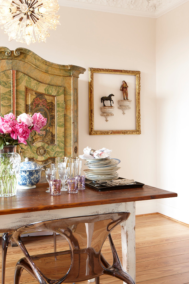 Imagen de comedor ecléctico con paredes blancas y suelo de madera en tonos medios