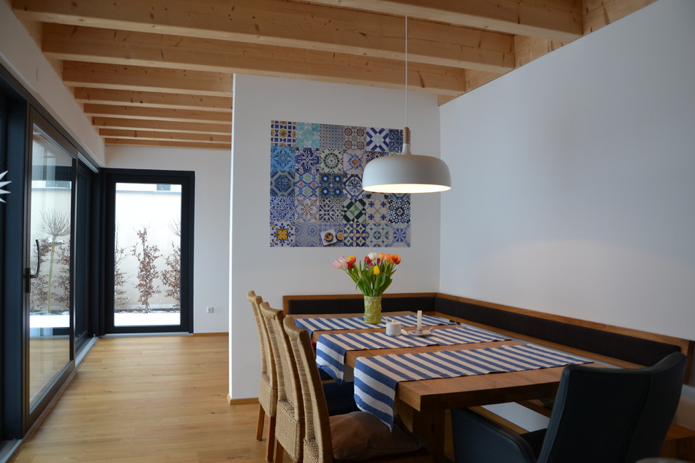 Geschlossenes, Mittelgroßes Landhaus Esszimmer ohne Kamin mit weißer Wandfarbe, braunem Holzboden und braunem Boden in Nürnberg