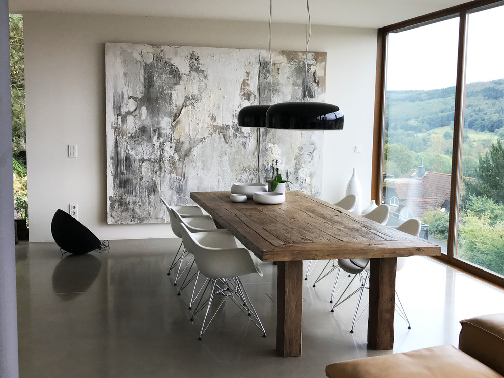 Источник вдохновения для домашнего уюта: огромная гостиная-столовая в стиле модернизм с белыми стенами, бетонным полом и серым полом без камина