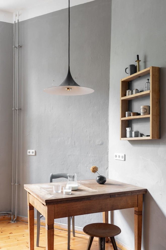 Ejemplo de comedor de cocina industrial pequeño sin chimenea con paredes grises, suelo de madera en tonos medios y suelo beige