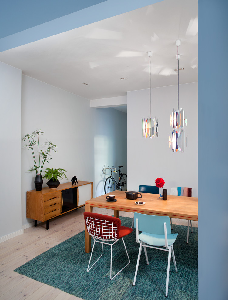 Foto di una sala da pranzo minimalista con pareti blu e parquet chiaro