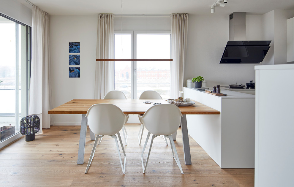 Esempio di una piccola sala da pranzo aperta verso il soggiorno scandinava con pareti bianche, parquet chiaro e pavimento beige