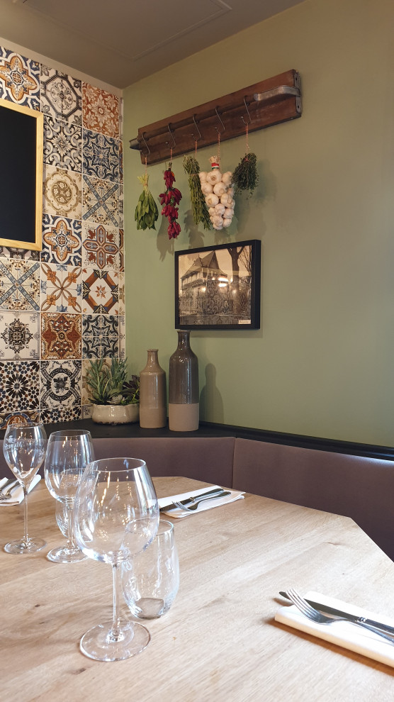 Idee per una sala da pranzo mediterranea con pareti verdi e stufa a legna