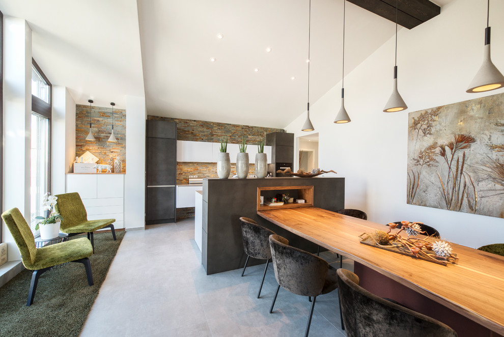 Large contemporary open plan dining room in Nuremberg with white walls, concrete flooring, no fireplace and grey floors.