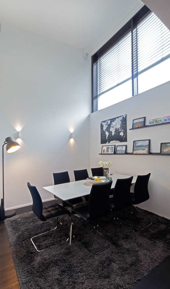 Medium sized contemporary open plan dining room in Stuttgart with white walls and dark hardwood flooring.