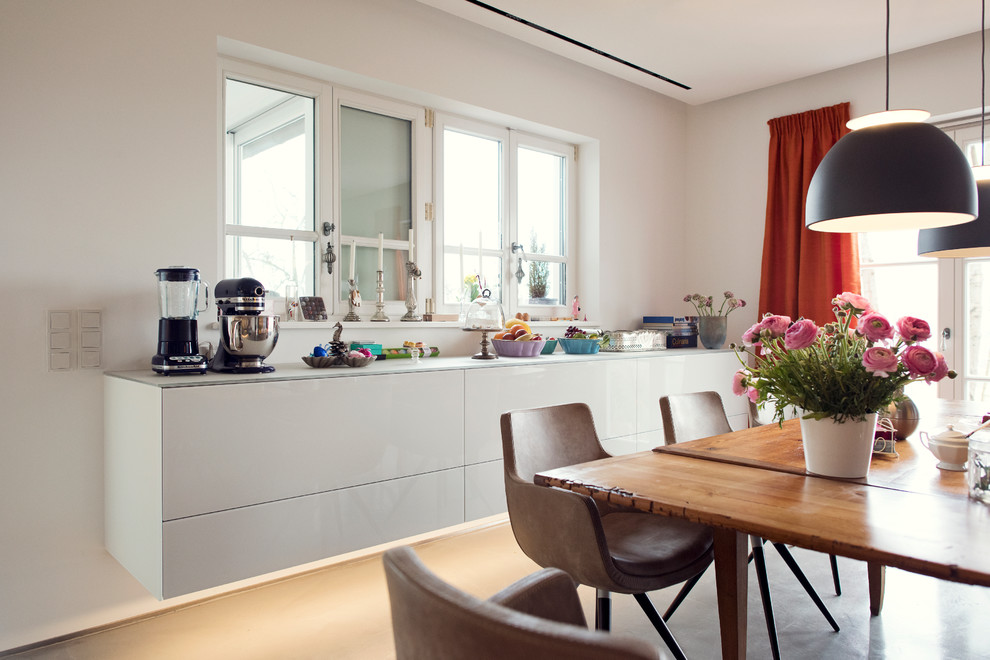 This is an example of a medium sized scandi kitchen/dining room in Frankfurt with white walls and beige floors.