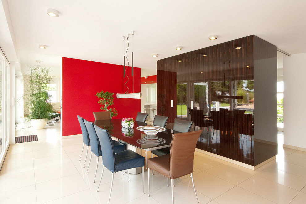 This is an example of a medium sized contemporary open plan dining room in Cologne with multi-coloured walls, ceramic flooring and beige floors.