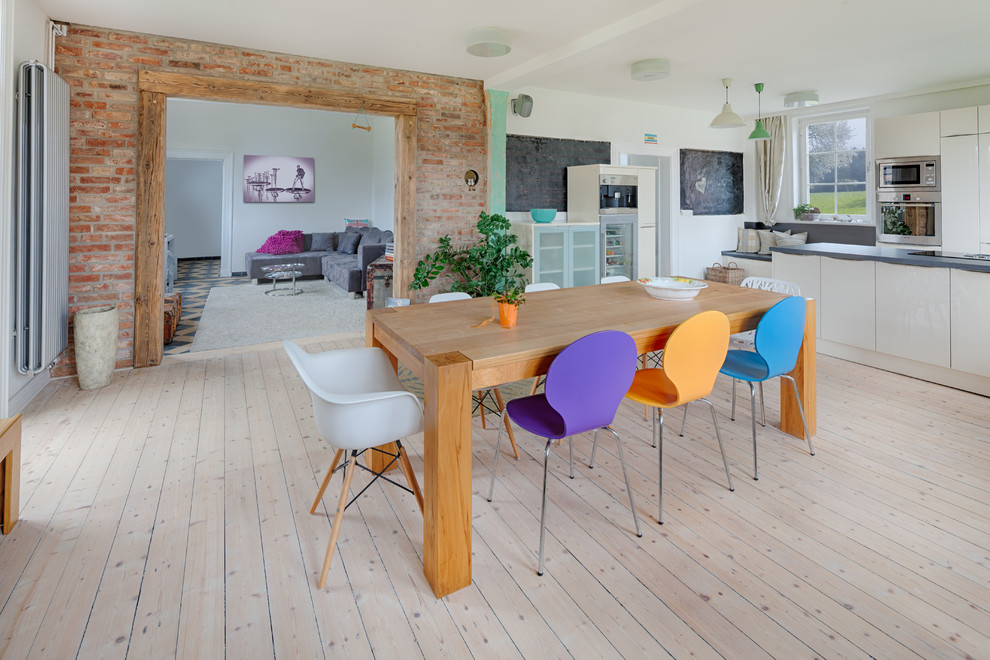 Geräumige Skandinavische Wohnküche mit weißer Wandfarbe und hellem Holzboden in Hannover