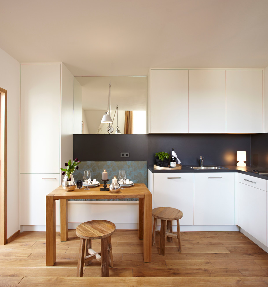 Пример оригинального дизайна: маленькая кухня-столовая в современном стиле с паркетным полом среднего тона, белыми стенами и бежевым полом для на участке и в саду