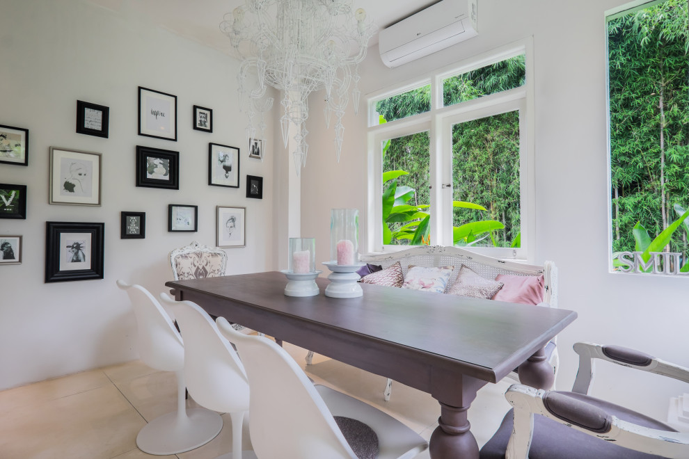 Cette image montre une petite salle à manger ouverte sur le salon design avec un mur blanc, sol en béton ciré et un sol beige.