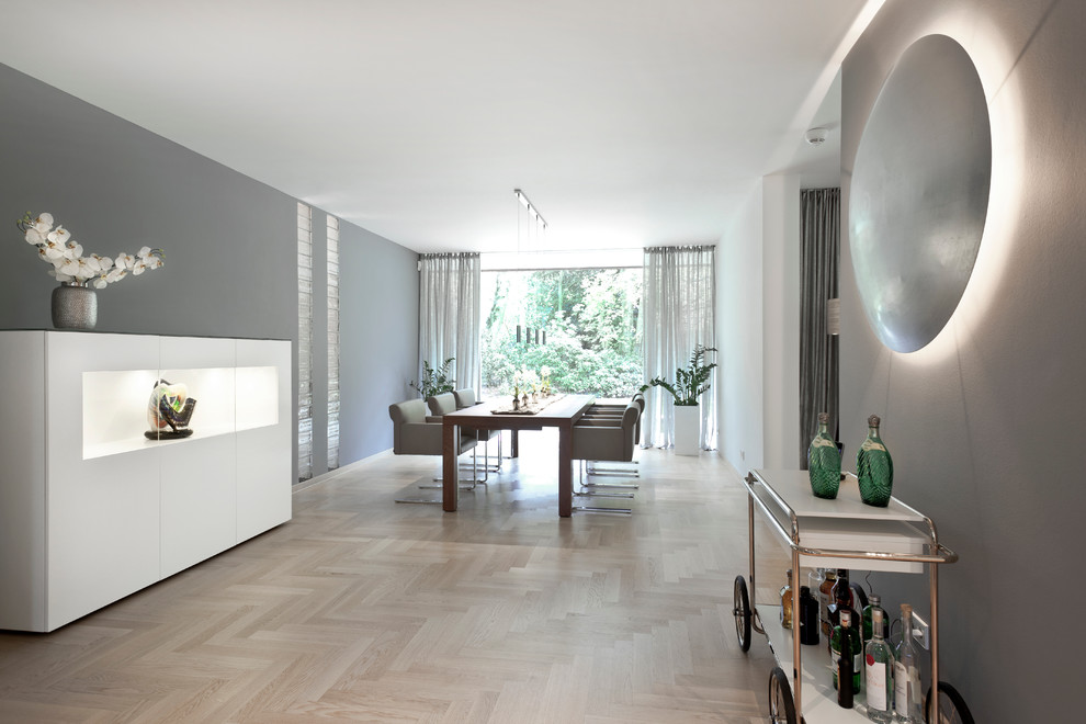 Modernes Esszimmer mit grauer Wandfarbe und hellem Holzboden in Bremen