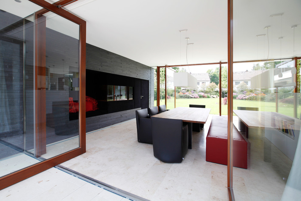 Immagine di una grande sala da pranzo minimalista con pavimento in pietra calcarea