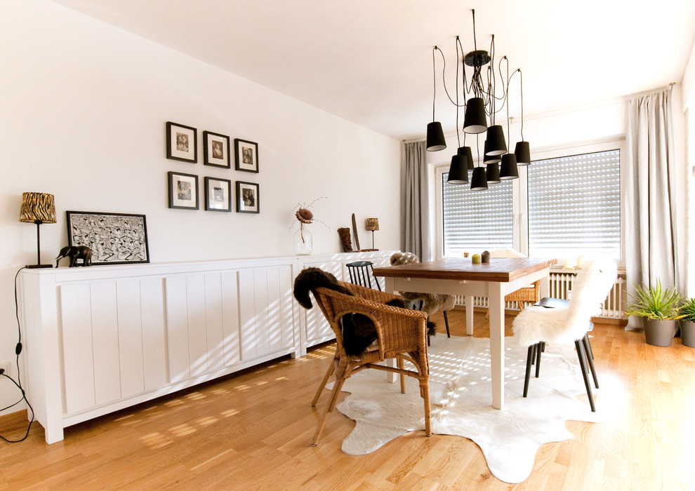 Esempio di una sala da pranzo scandinava di medie dimensioni con pareti bianche e parquet chiaro