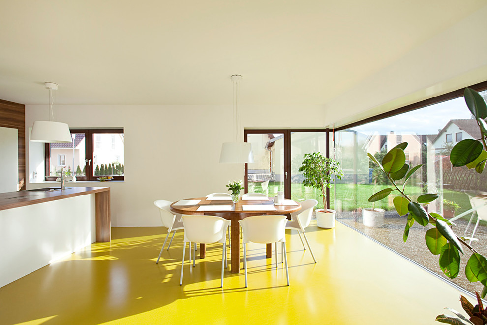 Foto di una sala da pranzo aperta verso la cucina design di medie dimensioni con pareti bianche e pavimento giallo