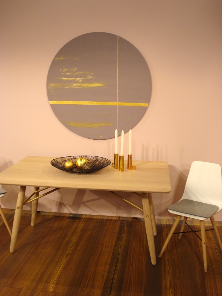 Cette image montre une salle à manger ouverte sur le salon nordique de taille moyenne avec un mur rose et parquet foncé.